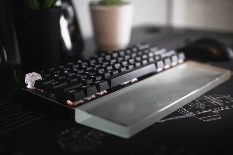 Close-up of a modern mechanical keyboard with a glass wrist rest, showcasing sleek design and innovation