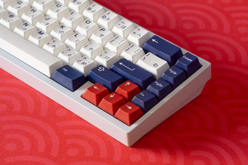 Close-up of a white and red mechanical keyboard with blue keys on a vibrant red surface