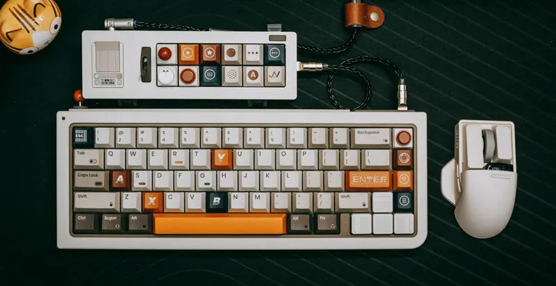 Overhead view of custom mechanical keyboard setup with accessories on black surface