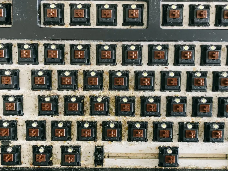 From above of keyboard panel without keycaps full of dust and dirt before cleaning