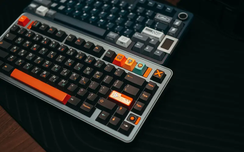 Close-up of colorful mechanical keyboards on a desk, showcasing unique keycaps and modern design