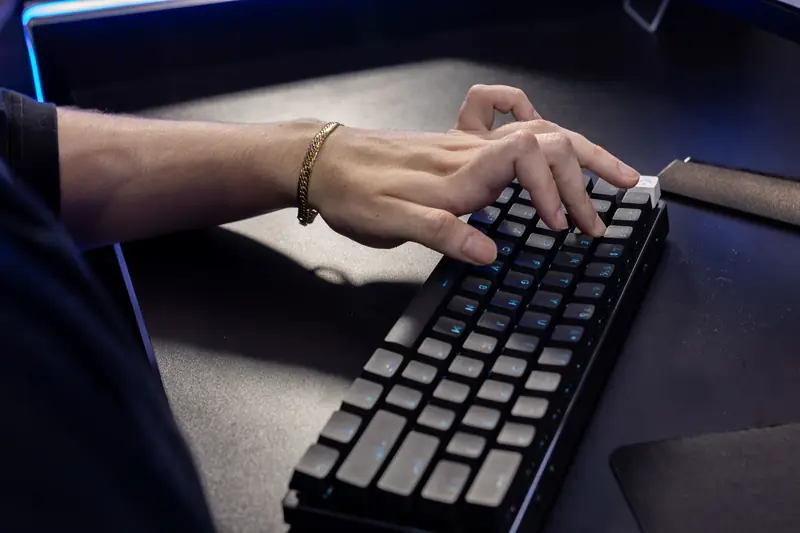 Close-up of a hand typing on a mechanical keyboard, highlighting modern technology and work