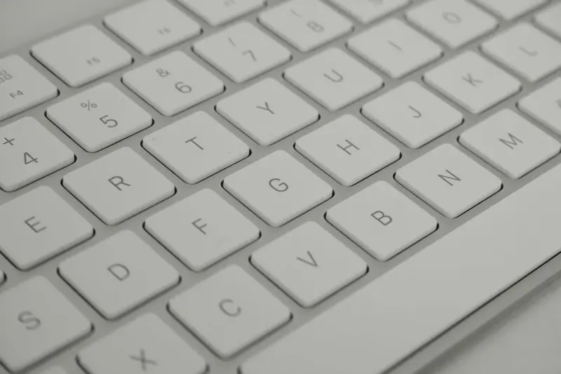 Detailed close-up of a sleek white keyboard, emphasizing modern technology