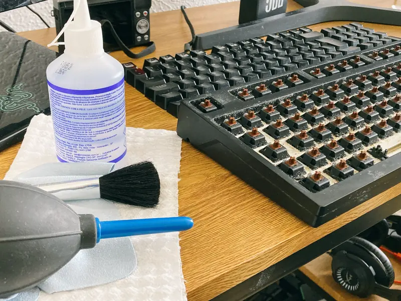 Set of tools and cleaning products for mechanical keyboard maintenance on a wooden desk