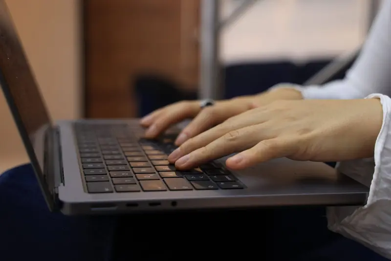 Hands typing on a laptop keyboard in an indoor setting. Perfect for business and technology themes